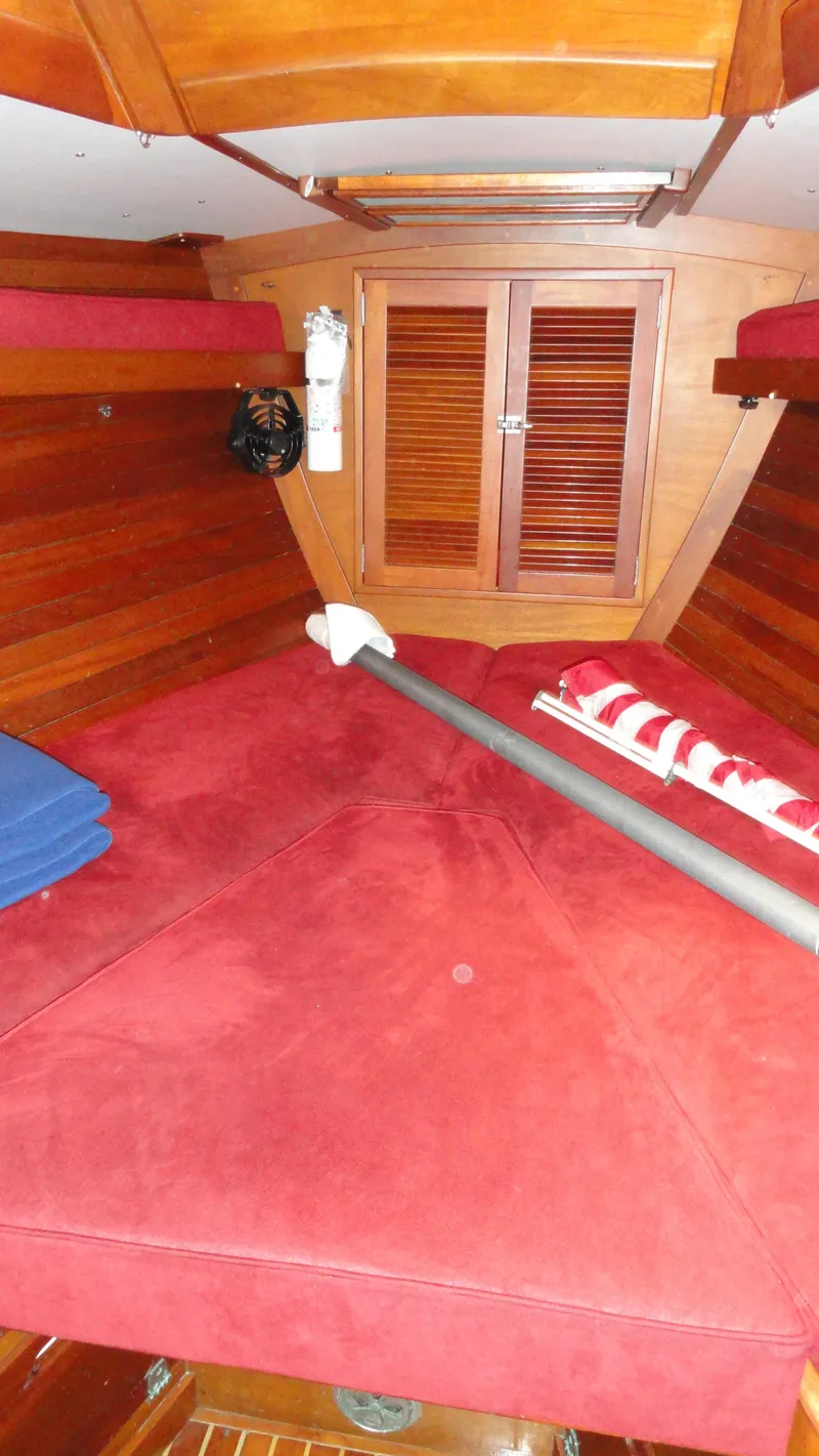 Slide: The Image of Interior of 1980 Hinckley 43 sailboat with red cushions and wooden paneling. - 34