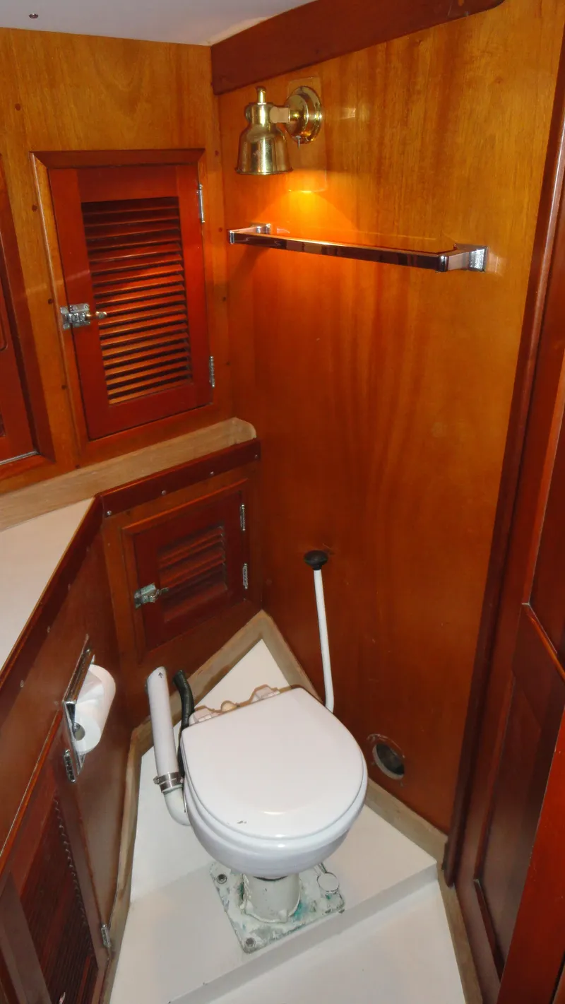 Slide: The Image of 1980 Hinckley 43 yacht bathroom with wooden cabinetry and marine toilet. - 36