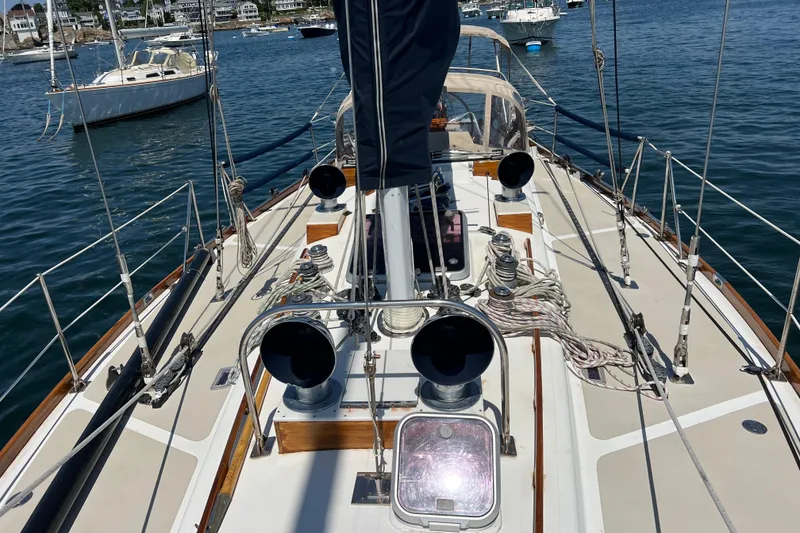 Slide: The Image of 1980 Hinckley 43 sailboat deck with ropes and winches in a marina setting. - 47