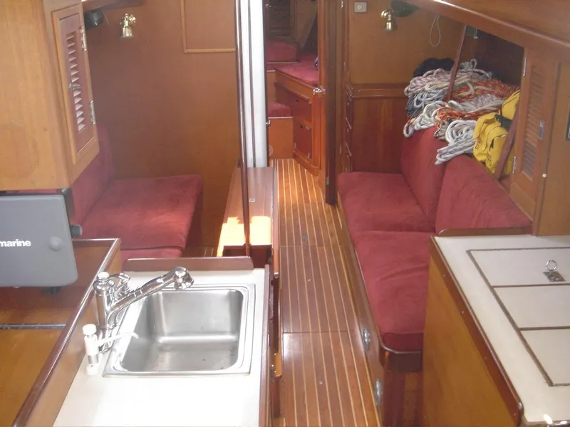 Slide: The Image of Interior of a 1980 Hinckley 43 yacht with wooden finishes and red seating. - 5