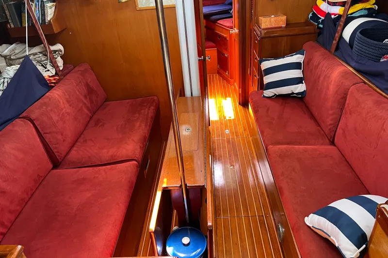 Slide: The Image of Interior of 1980 Hinckley 43 yacht with red seating and striped pillows. - 51