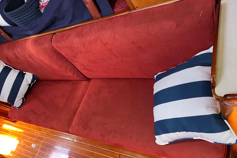 Slide: The Image of Red cushioned seating with striped pillows on a 1980 Hinckley 43 boat interior. - 52
