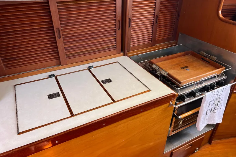 Slide: The Image of 1980 Hinckley 43 yacht kitchen with wooden cabinets and stove. - 53