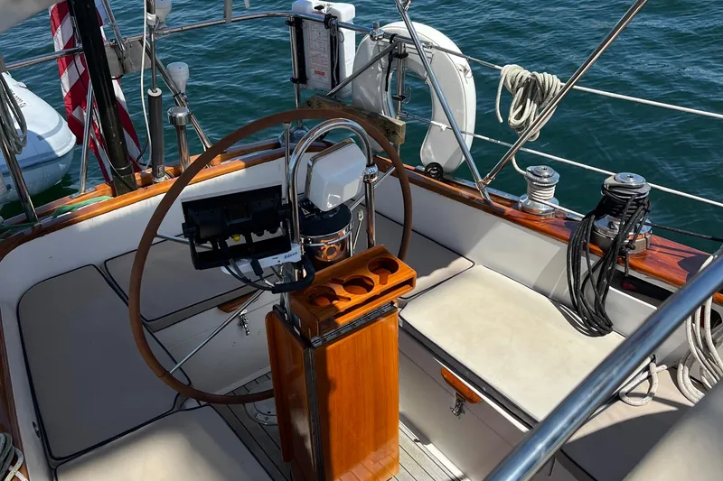Slide: The Image of Cockpit of a 1980 Hinckley 43 sailboat with wooden steering wheel and seating. - 62