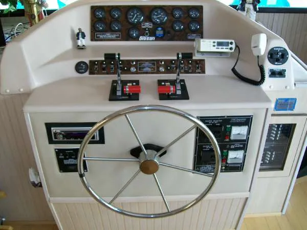 Slide: The Image of 1999 Gibson 44 Standard Houseboat helm with instruments and steering wheel. - 12