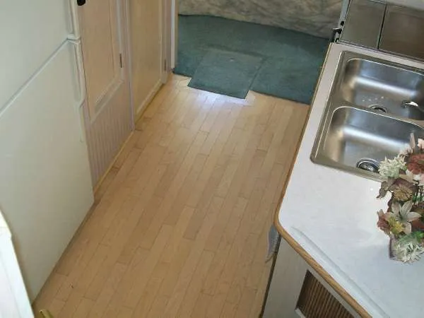Slide: The Image of Interior of a 1999 Gibson 44 Standard Houseboat with wooden floor and sink. - 13