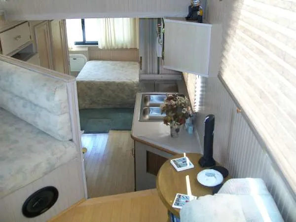Slide: The Image of Interior of a 1999 Gibson 44 Standard houseboat with kitchen and sleeping area. - 14