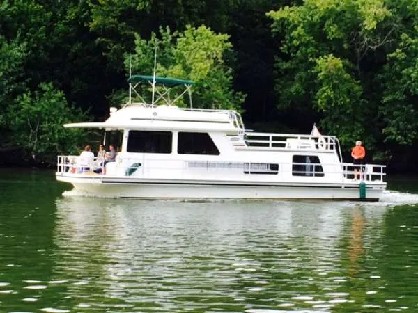 Slide: The Image of 1999 Gibson 44 Standard houseboat cruising on a serene river. - 2