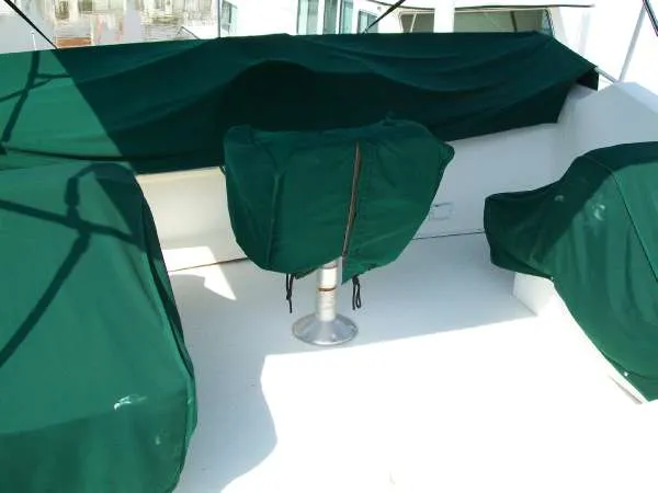 Slide: The Image of 1999 Gibson 44 Standard Houseboat with green covers on deck. - 7