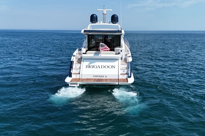 Slide: The Image of Azimut 55S yacht from 2016 cruising on open water, rear view with American flag. - 6