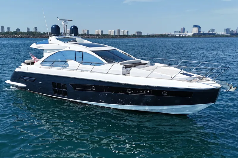 The Image of Luxury 2016 Azimut 55S yacht cruising on open water with city skyline backdrop. - 0