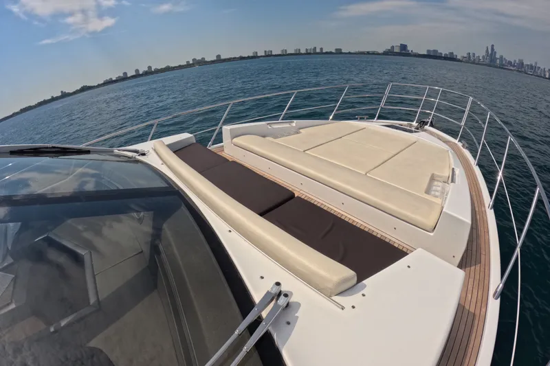 Slide: The Image of 2016 Azimut 55S yacht with sunbathing deck, cruising on open water near city skyline. - 26