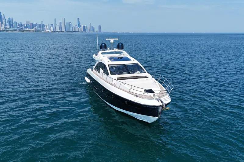 Slide: The Image of 2016 Azimut 55S yacht cruising on open water with city skyline in background. - 3