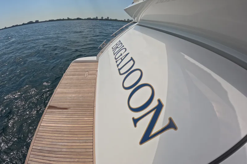 Slide: The Image of Azimut 55S yacht "Brigadoon" on water, showcasing elegant design and wooden deck. - 34