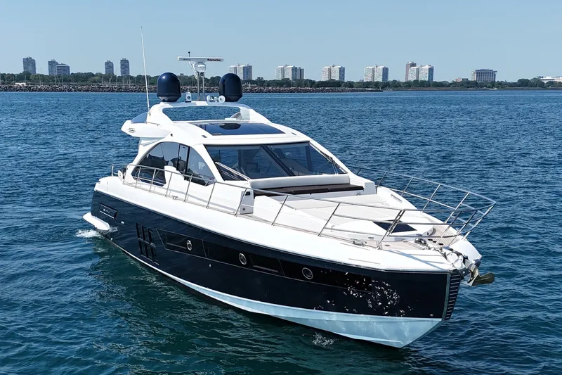 Slide: The Image of Luxury 2016 Azimut 55S yacht cruising on blue water with city skyline backdrop. - 2