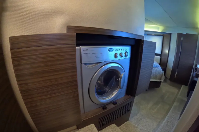 Slide: The Image of Laundry area inside 2016 Azimut 55S yacht, featuring a built-in washing machine. - 94