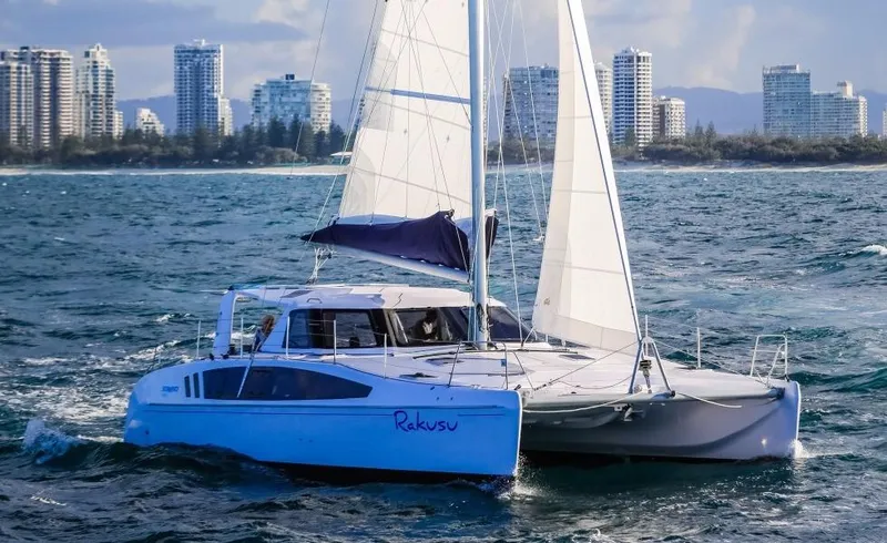 Slide: The Image of 2024 Seawind 1260 Owners Version catamaran sailing near a city skyline. - 10