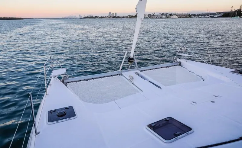 Slide: The Image of 2024 Seawind 1260 Owners Version catamaran on calm waters at sunset. - 13