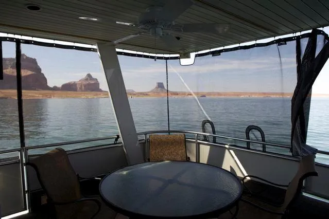 Slide: The Image of Sumerset 2006 houseboat interior with lake view, featuring a round table and chairs. - 10
