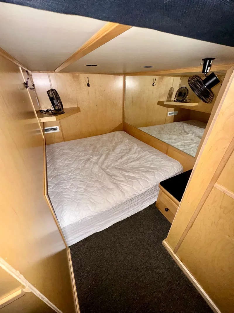 Slide: The Image of Cozy bedroom in 2006 Sumerset Seas The Day Trip 4 houseboat, featuring wood paneling and built-in shelves. - 29