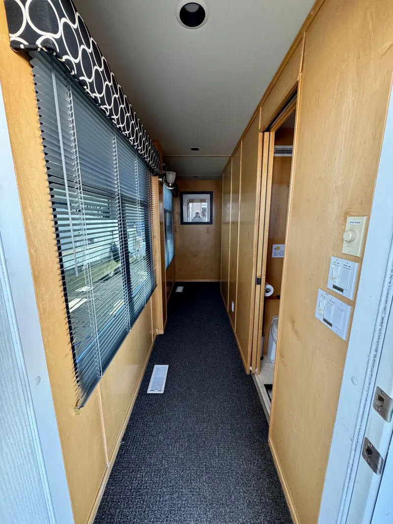 Slide: The Image of Narrow hallway inside 2006 Sumerset Seas The Day Trip 4 houseboat, featuring wood paneling and carpet. - 31