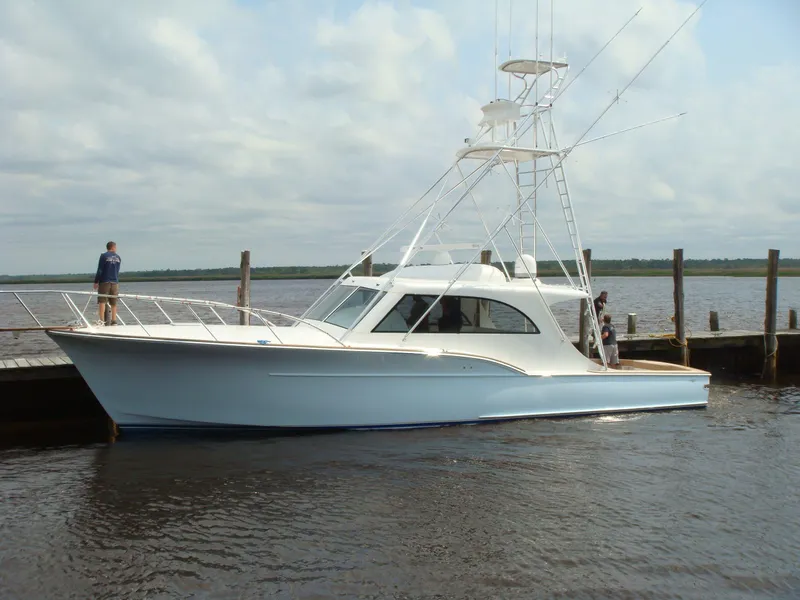 Slide: The Image of 2024 Jersey Cape 47 Custom Hardtop docked at a marina. - 1