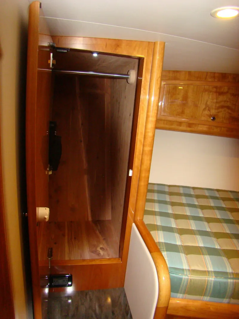 Slide: The Image of Interior cabin of 2024 Jersey Cape 47 Custom Hardtop with wooden closet and bed. - 11