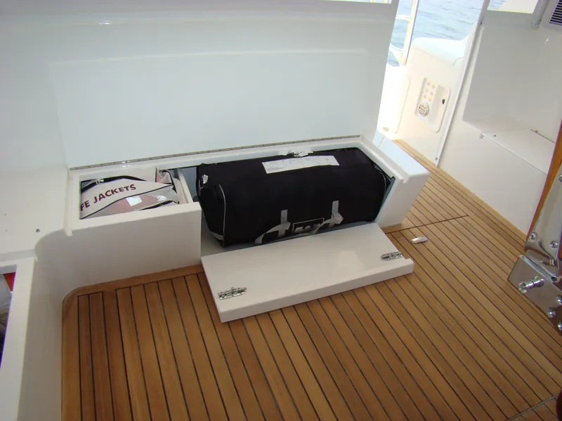Slide: The Image of 2024 Jersey Cape 47 Custom Hardtop storage compartment with life jackets and gear bag. - 13