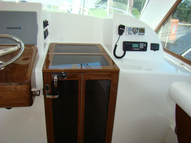 Slide: The Image of 2024 Jersey Cape 47 Custom Hardtop helm station with Garmin electronics and communication equipment. - 18