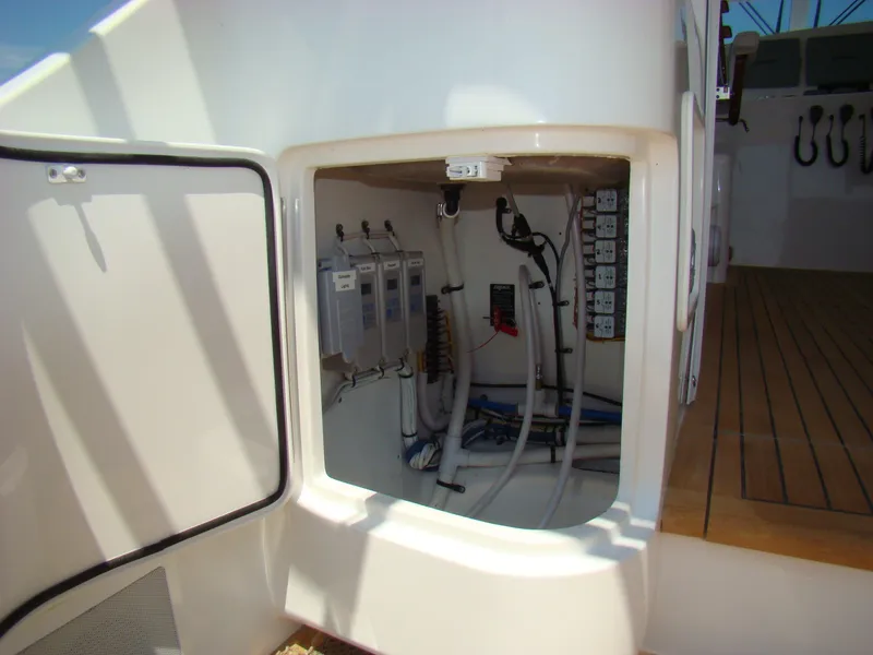 Slide: The Image of Electrical compartment of 2024 Jersey Cape 47 Custom Hardtop boat with wiring and control panels. - 22