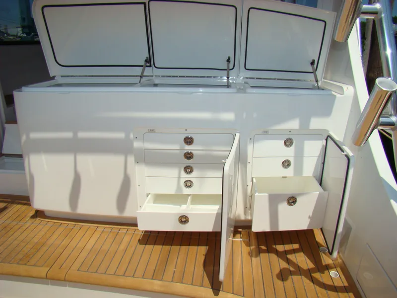 Slide: The Image of 2024 Jersey Cape 47 Custom Hardtop with open storage compartments on teak deck. - 23