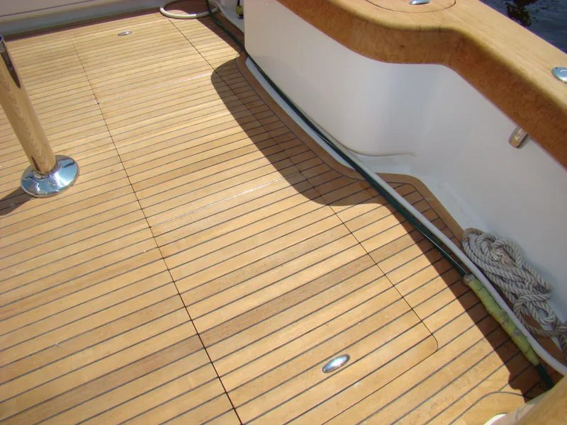 Slide: The Image of 2024 Jersey Cape 47 Custom Hardtop teak deck with polished fittings and coiled rope. - 25