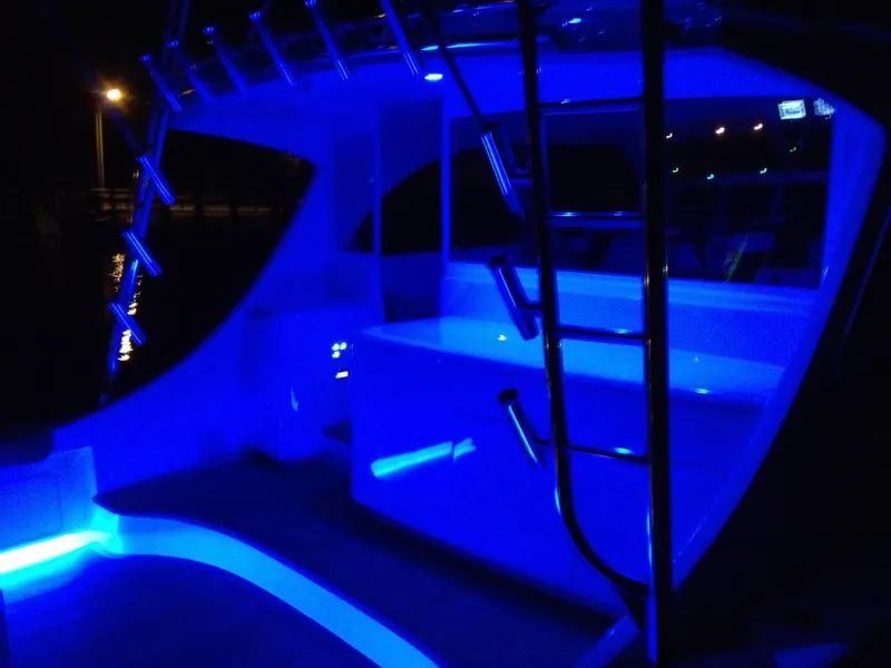 Slide: The Image of 2024 Jersey Cape 47 Custom Hardtop with blue LED lighting at night. - 38