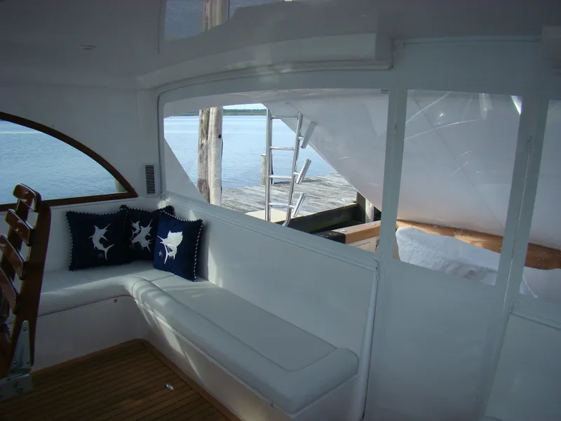 Slide: The Image of Interior of 2024 Jersey Cape 47 Custom Hardtop yacht with white seating and nautical pillows. - 42