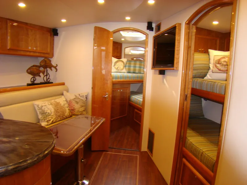 Slide: The Image of 2024 Jersey Cape 47 Custom Hardtop interior with cozy seating and bunk beds. - 43
