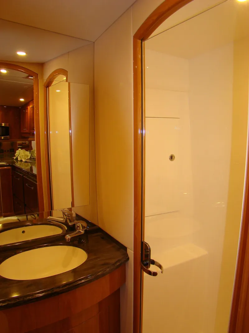 Slide: The Image of 2024 Jersey Cape 47 Custom Hardtop yacht bathroom with dual sinks and shower. - 47
