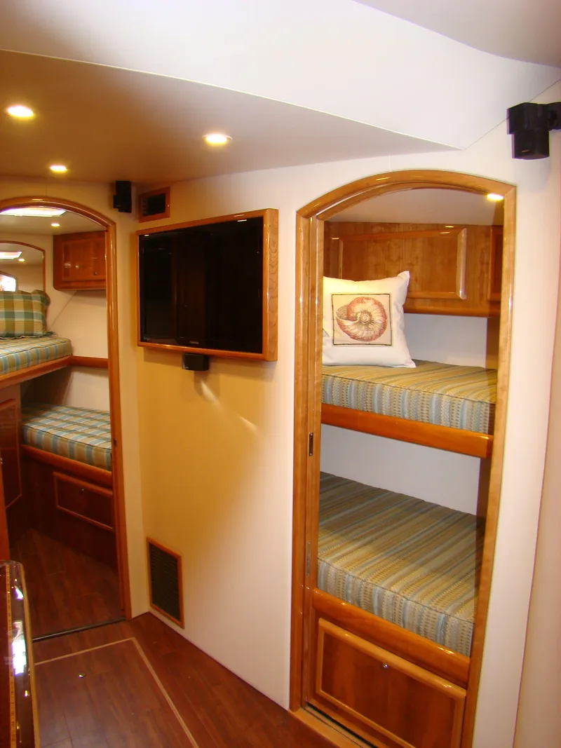 Slide: The Image of 2024 Jersey Cape 47 Custom Hardtop interior with bunk beds and TV. - 48