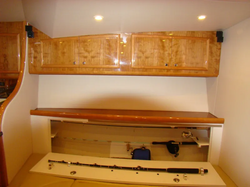 Slide: The Image of Interior storage area of 2024 Jersey Cape 47 Custom Hardtop boat with wooden cabinets. - 8
