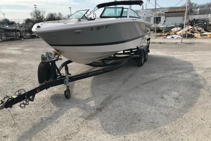 Slide: The Image of 2015 Four Winns H230 boat on trailer in outdoor storage area. - 13