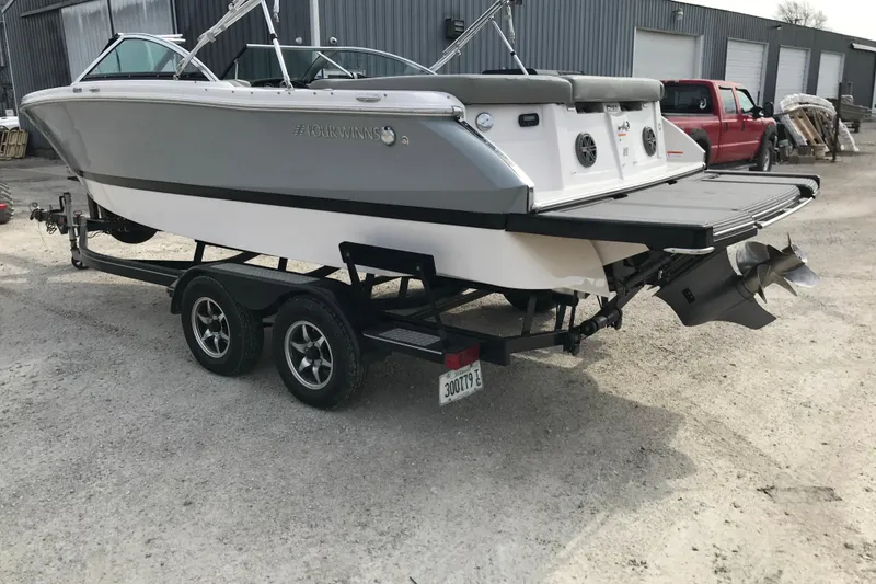 Slide: The Image of 2015 Four Winns H230 boat on trailer, gray and white exterior, parked outdoors. - 17
