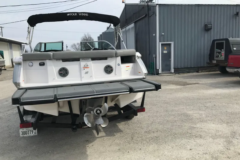 Slide: The Image of 2015 Four Winns H230 boat rear view in a parking area. - 19