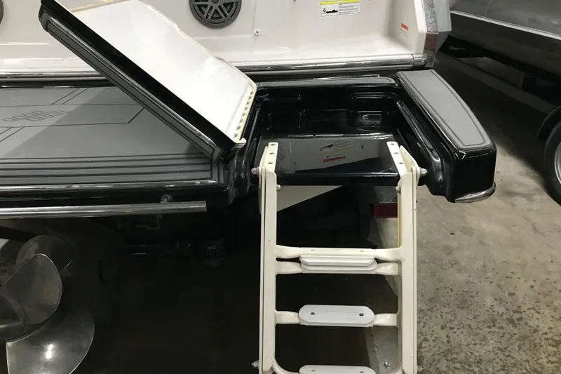 Slide: The Image of 2015 Four Winns H230 boat with open storage compartment and swim ladder. - 23