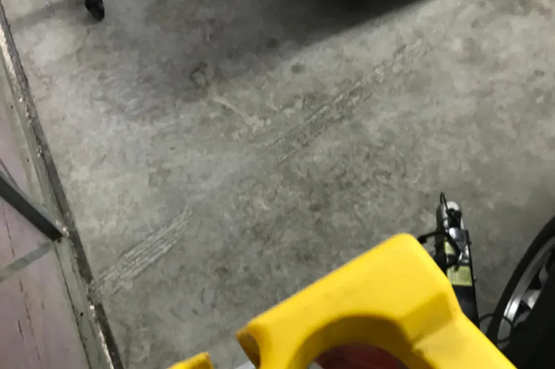 Slide: The Image of Concrete floor with yellow object and partial view of a wheel, possibly in a garage. - 27