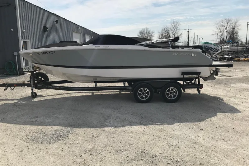 Slide: The Image of 2015 Four Winns H230 boat on trailer, parked outdoors. - 3