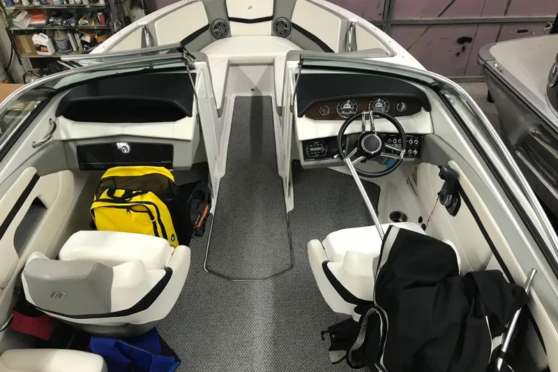 Slide: The Image of 2015 Four Winns H230 boat interior with steering wheel, seats, and storage compartments. - 31