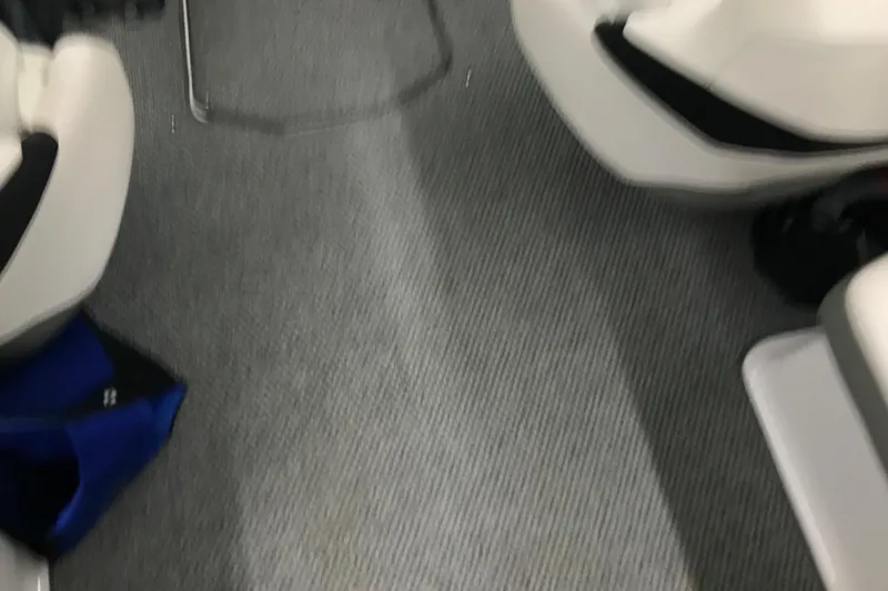 Slide: The Image of Interior of a 2015 Four Winns H230 boat with gray carpet and white seating. - 33