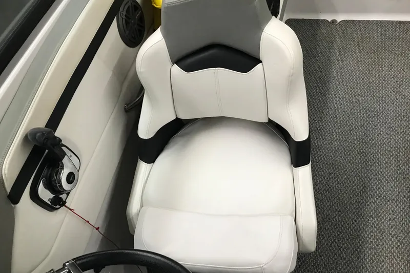 Slide: The Image of Captain's seat in 2015 Four Winns H230 boat, featuring white upholstery and control panel. - 68