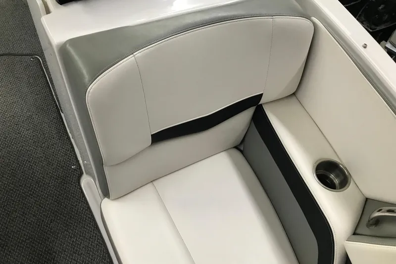 Slide: The Image of 2015 Four Winns H230 boat interior seating with cup holder, featuring gray and white upholstery. - 76