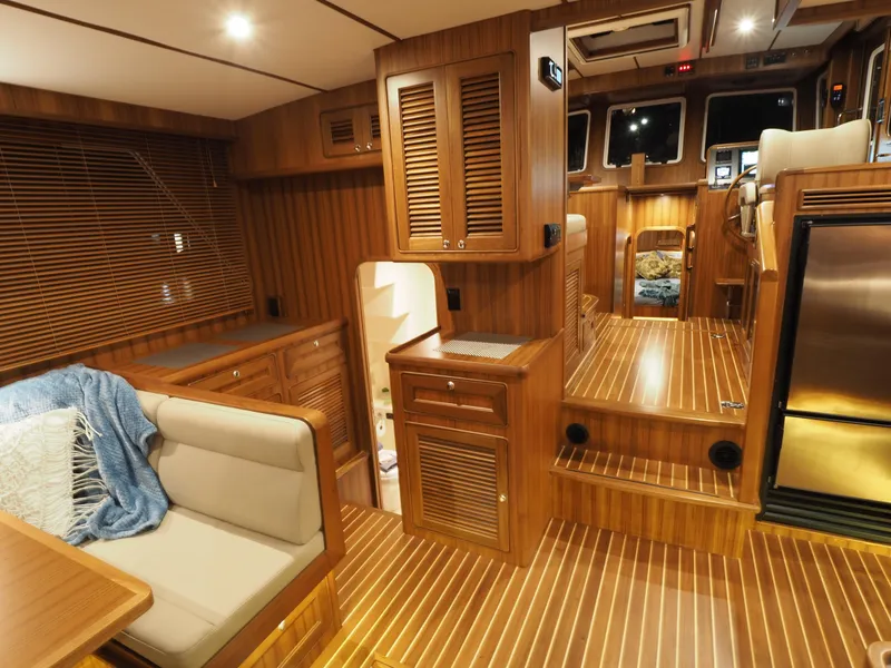 Slide: The Image of Luxurious interior of 2026 Helmsman Trawlers 43E Pilothouse with wood finish and cozy seating. - 11