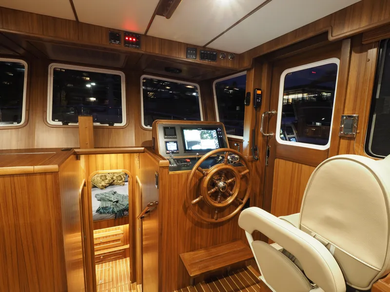 Slide: The Image of 2026 Helmsman Trawlers 43E PILOTHOUSE interior with wood finish and navigation equipment. - 15